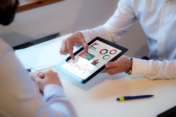 businessman showing financial strategy on a tablet in a business meeting. All screen graphics are made up.